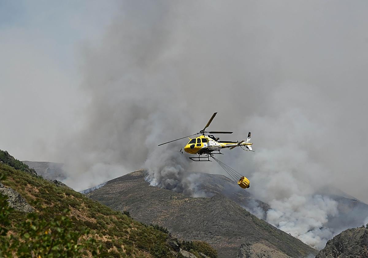 Un helicóptero cargado de agua va en dirección a un incendio forestal declarado este sábado en los Picos de Europa.