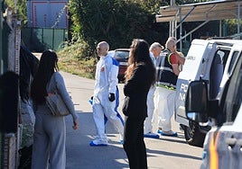Los abogados de Isaías M. C., Angela Morán Alonso y Juan Antonio Gómez, observan a los agentes de la Policía Científica en el exterior de la vivienda de la víctima.