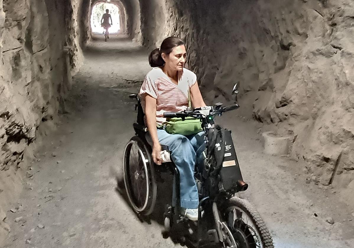 Silvia Valdezate, en la zona del túnel de la Senda del Oso en la que sufrió el accidente, con su silla de ruedas automotriz.