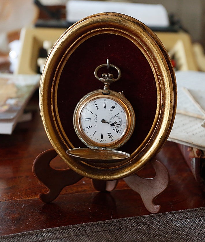 Imagen secundaria 2 - Flor Hevia, en su casa, con objetos personales de Víctor Labrada como su máquina de escribir, sus libros y, en las fotos 2 y 3, un borrador de su libro de Cimadevilla y su reloj de bolsillo.