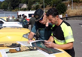 Agentes de la Guardia Civil y Bomberos revisan el mapa de la zona.