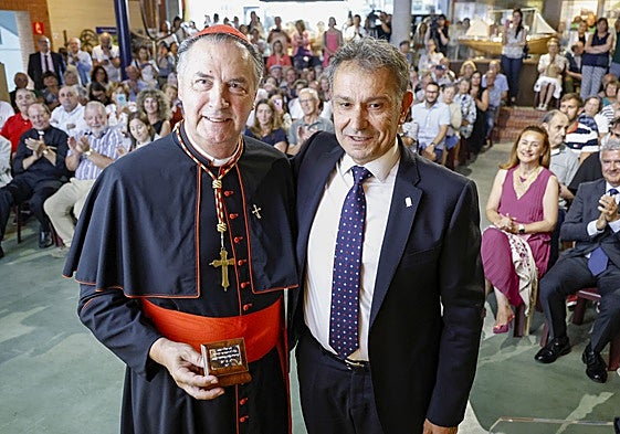 El cardenal Ángel Fernández Artime, con la distinción de Hijo Predilecto de Gozón en la mano, junto al alcalde Jorge Suárez.