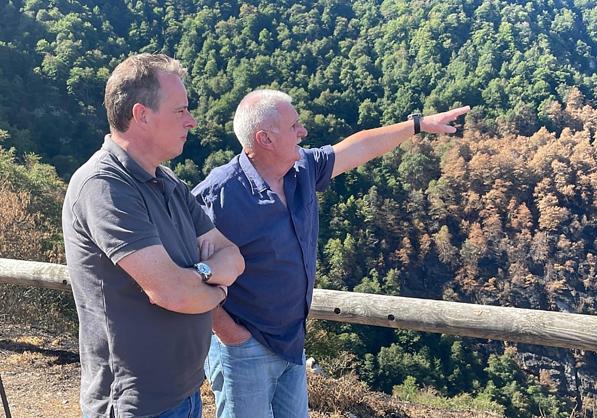 El alcalde de Caso, Miguel Ángel Fernández, muestra al consejero de Medio Rural y Política Agraria, Marcelino Marcos, la zona quemada en el concejo.