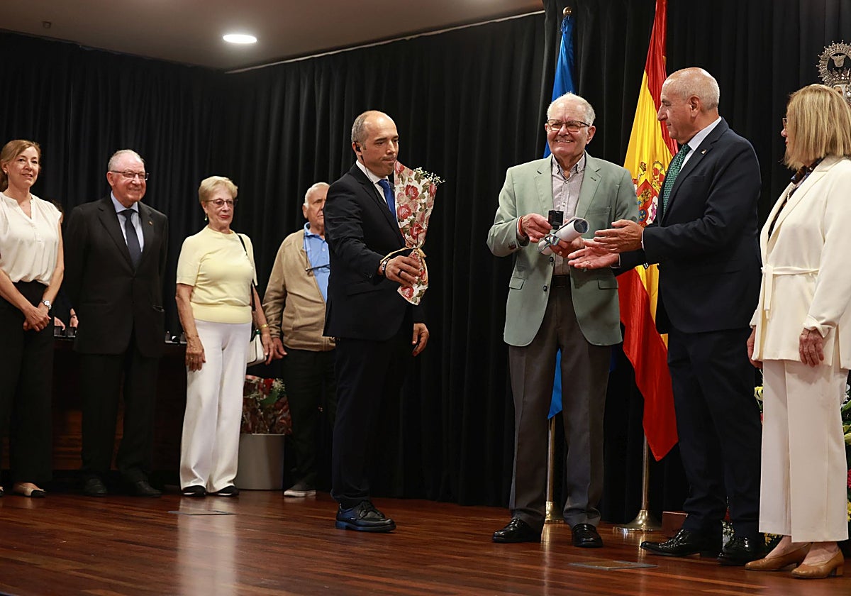 El presidente del Centro de Asturias entrega una de las distinciones de 'Socio de Mérito'.