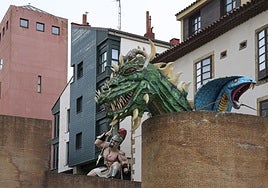 La figura de un romano, la cabeza de un dragón y la de una serpiente decoran los restos de la antigua muralla en Cimavilla.