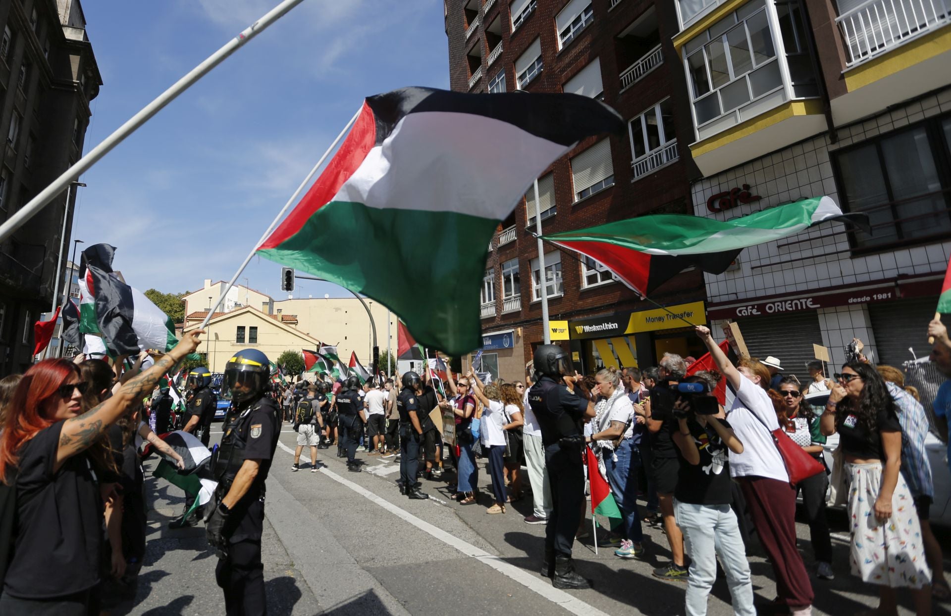 Manifestantes con banderas palestinas al paso de los corredores.