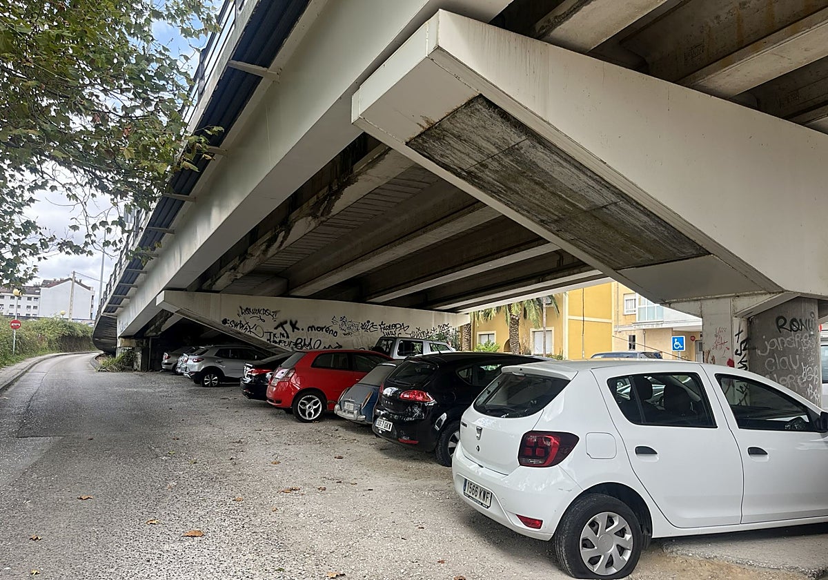 Coches con las ruedas rajadas bajo el puente de la avenida de Langreo, en El Berrón.