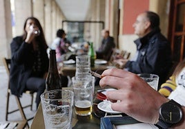 Una persona fuma en una terraza hostelera de Gijón.