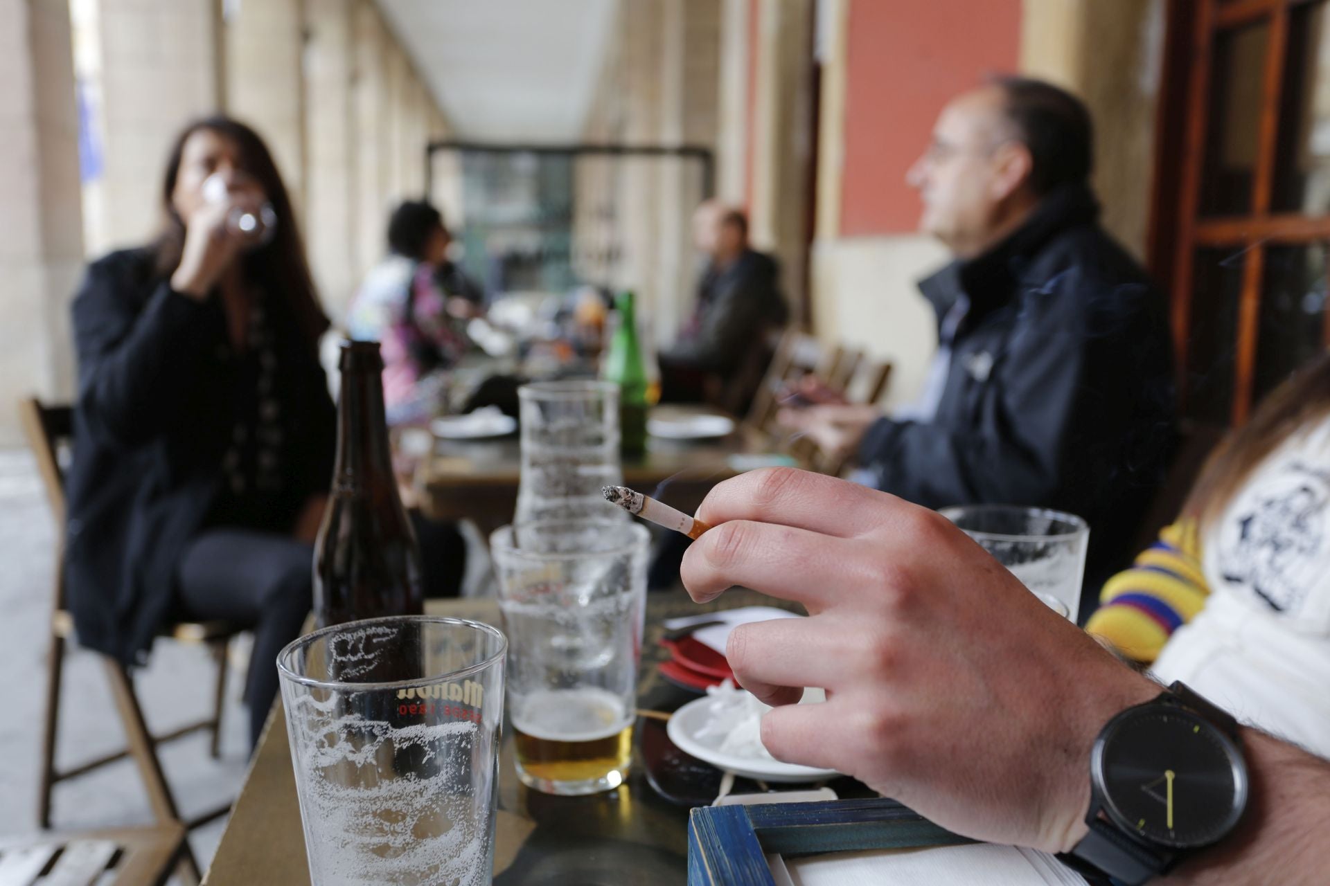 Una persona fuma en una terraza hostelera de Gijón.