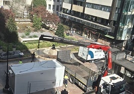 Una grúa descarga una caseta de obra en el inicio de la transformación de la plaza de Longoria Carbajal.