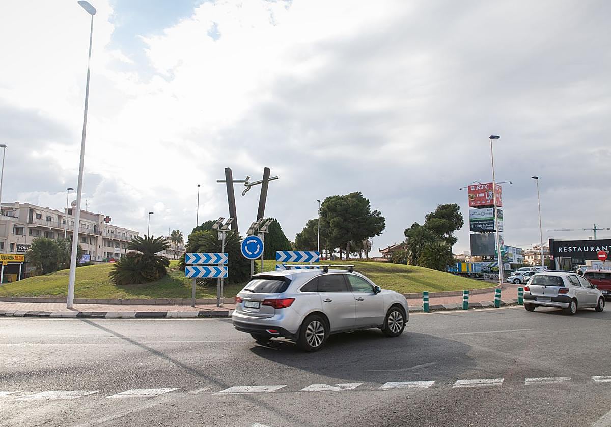 Varios coches circulan por una glorieta.