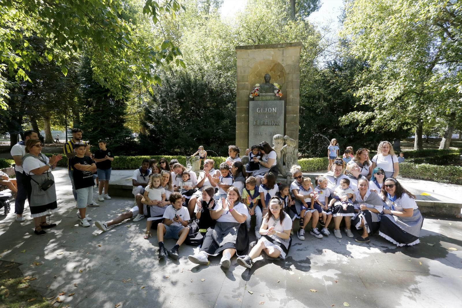 Vestidos de sardineres, niños y adultos aplauden ante el busto de Fleming.