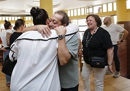 Víctor Fernández se abraza a una clienta en el último día de la sidrería El Chaflán.