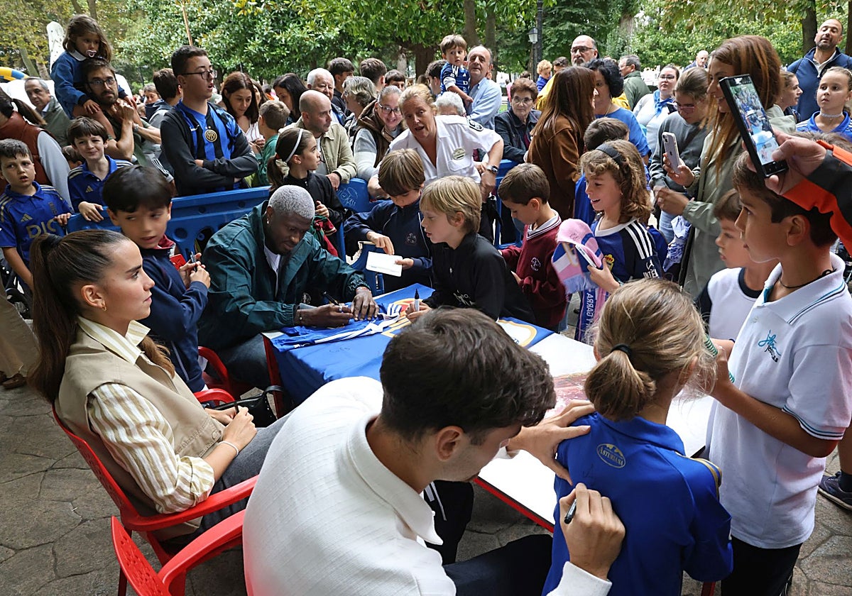 Los jugadores David Carmo, Carol Férez y Rahim firmando camisetas en el día del Real Oviedo en San Mateo.