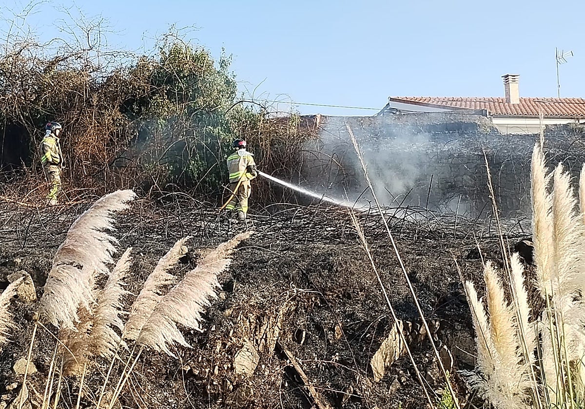 Los bomberos, en la finca incendiada este miércoles junto al poblado de Santa Bárbara.