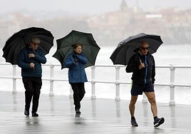 Tres personas en un día de mal tiempo en Asturias.
