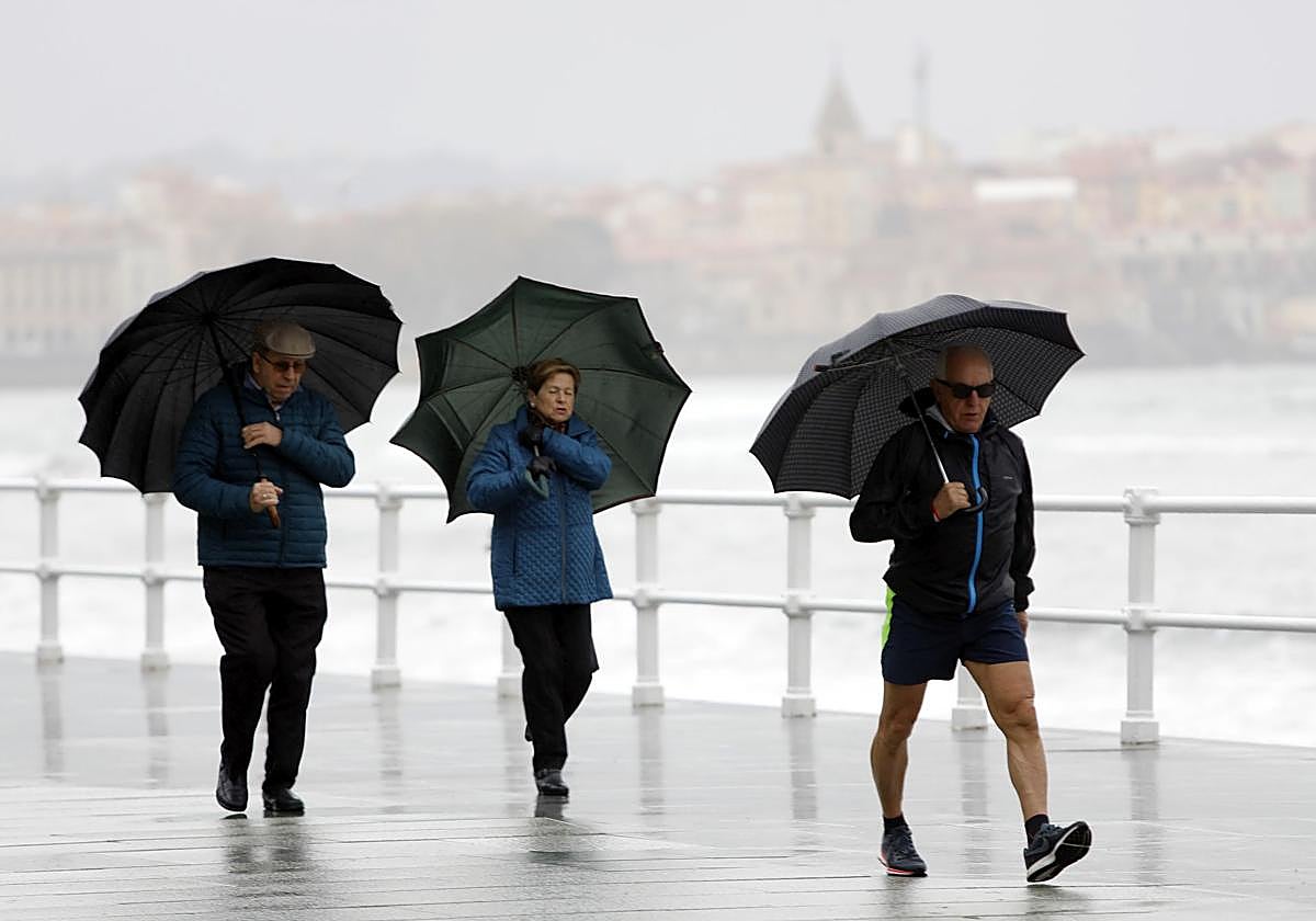 Tres personas en un día de mal tiempo en Asturias.