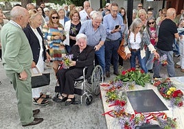Los familiares de las víctimas de la fosa de La Garba dejan flores en los nichos reservados del cementerio municipal de Grado.
