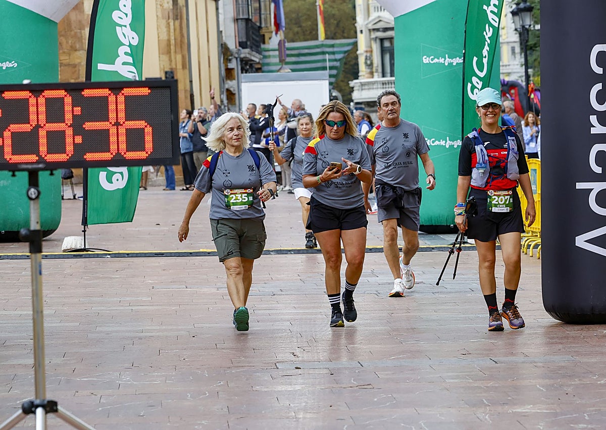 Imagen secundaria 1 - Ganadores de la carrera competitiva y un momento de la llegada de los caminantes.