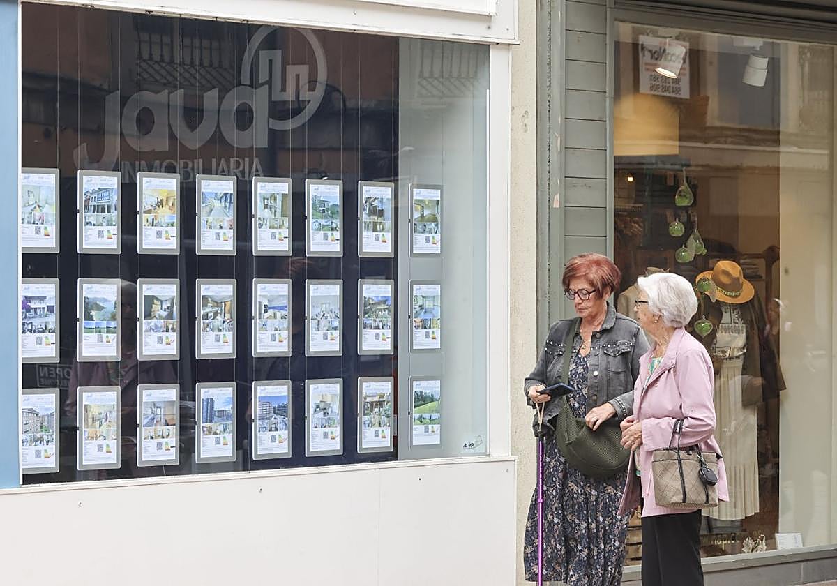 Dos mujeres pasan ante el escaparate de la inmobiliaria Java, en la calle Rui Pérez.