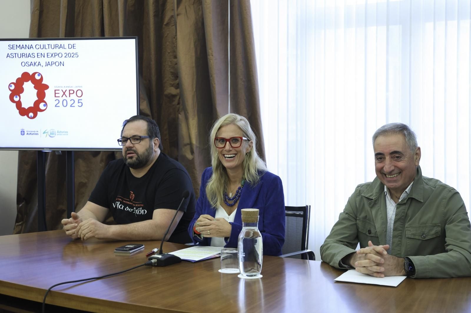 José Luis García, presidente de la Banda de Gaitas Villa de Xixón, Lara Martínez, viceconsejera de Turismo, y Luis Alberto Martínez, responsable de Casa Fermín, durante la presentación.