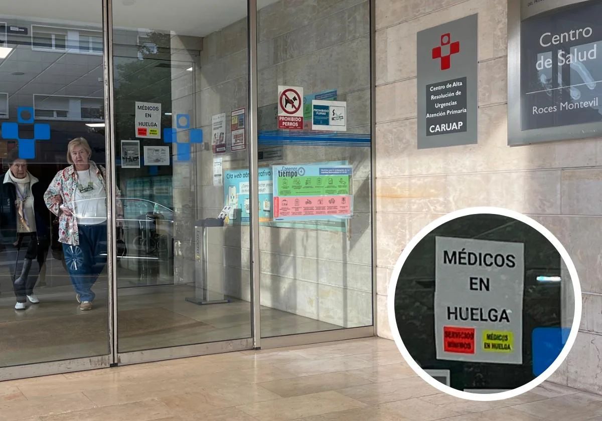 Dos mujeres salen del centro de salud de Roces Montevil mientras puede leerse un cartel en la puerta que avisa de la huelga de médicos
