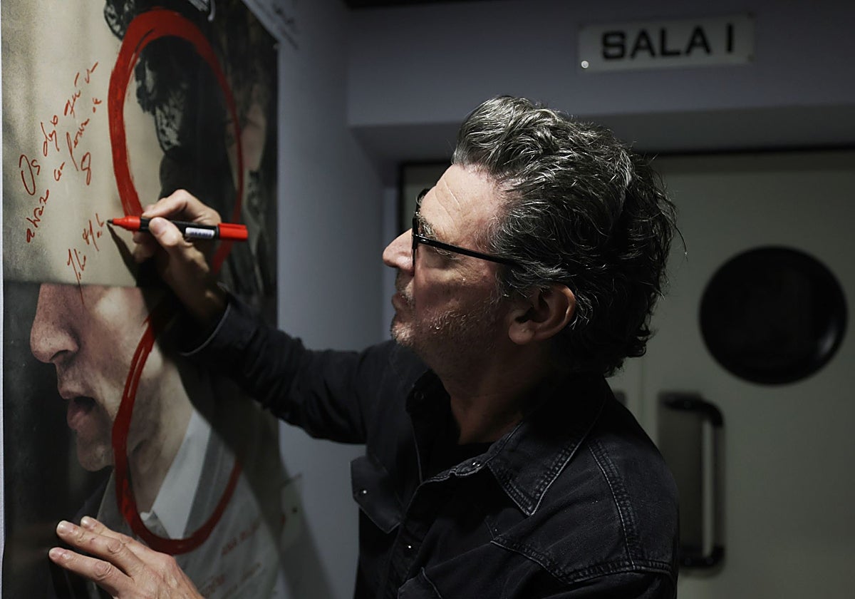 El realizador firma el cartel de una de sus películas.