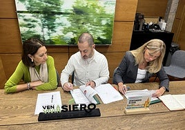 Ángel García, 'Cepi', y Alejandra Cuadriello firman el acuerdo presupuestario ante la mirada de la edil Patricia Antuña (izquierda).