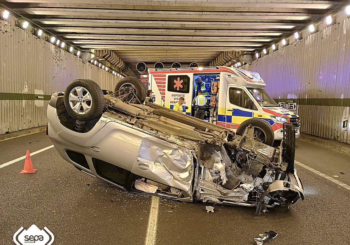 Coche volcado del que ayer fue excarcelado un varón de 70 años herido leve en la AS-114.