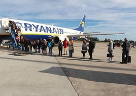 Viajeros se suben a un avión de Ryanair en el aeropuerto de Asturias.