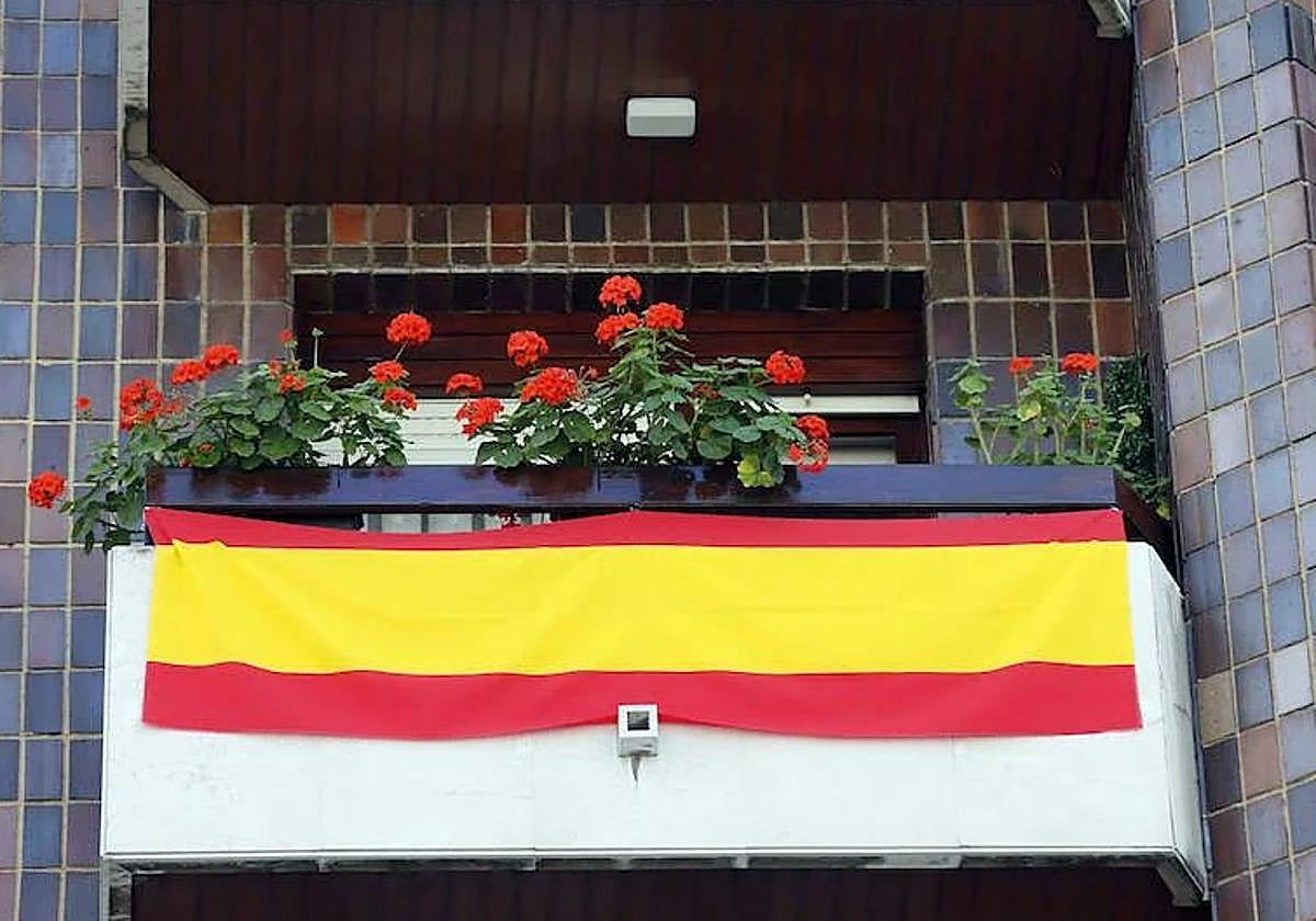 Un balcón luciendo la bandera de España.