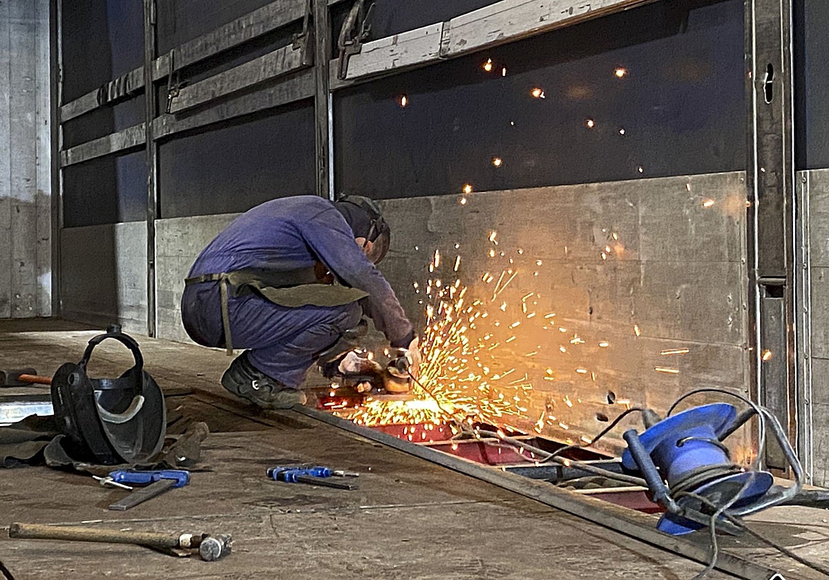 Un profesional del metal trabaja en un taller de soldadura, en Gijón.