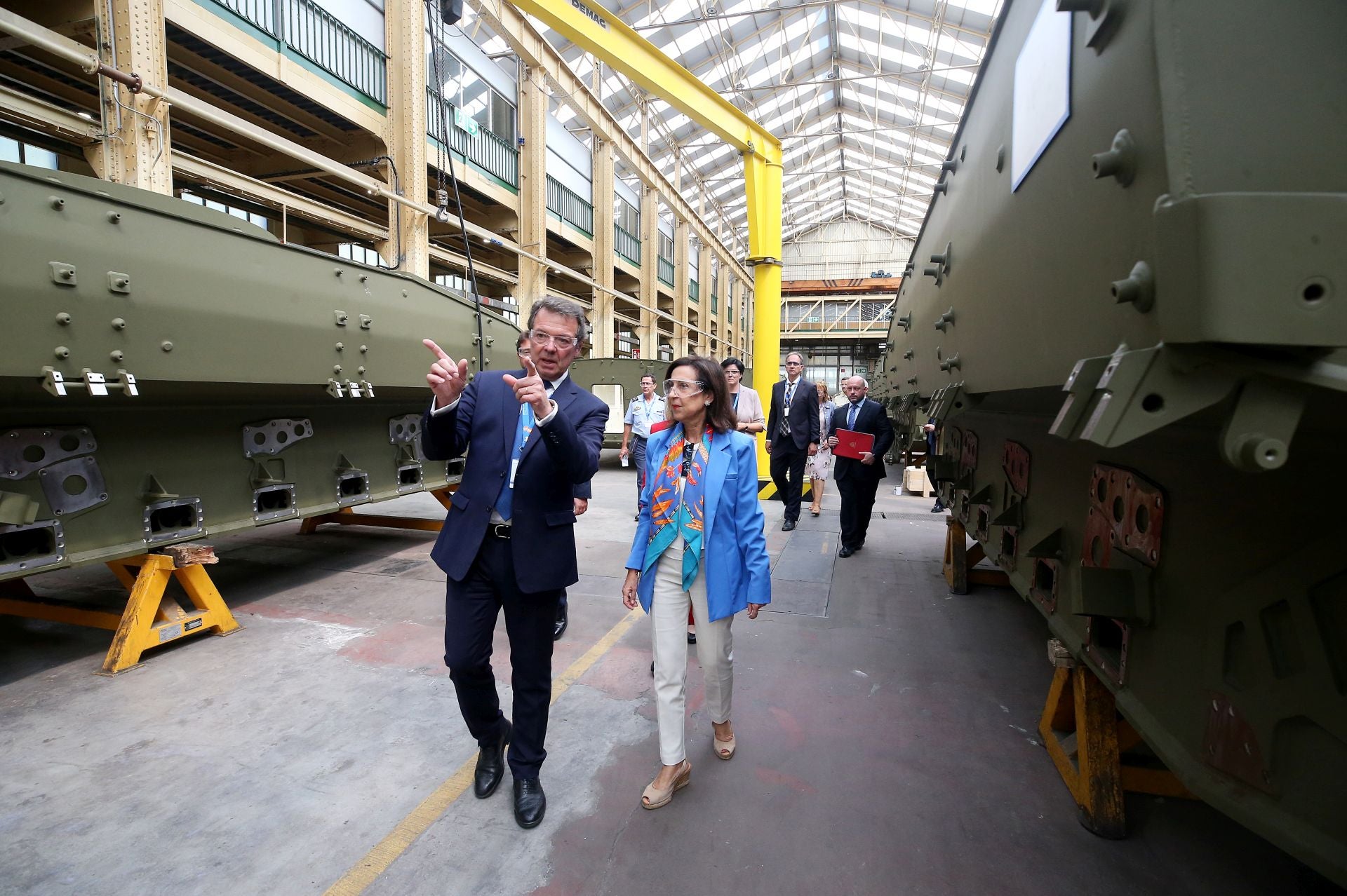 El exdirector general de Santa Bárbara Sistemas, Juan Escriña, explica a la ministra de Defensa, Margarita Robles, el proceso de fabricación de los VCR 8x8 Dragón, durante una visita a la fábrica de armas de Trubia.