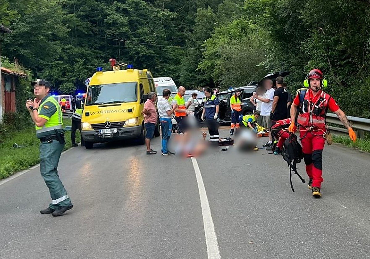 Guardia Civil, Bomberos y sanitarios atienden a las víctimas del accidente, en una curva próxima a la localidad de Vibañu de la carretera de Posada de Llanes a La Robellada.