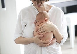 Una mujer sostiene a su bebé.