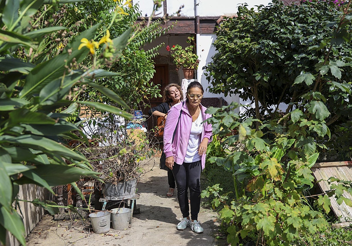 Mar Berjón, en primer término, seguida de su hermana Magdalena, salen de la casa de Cuevas del Agua (Ribadesella).