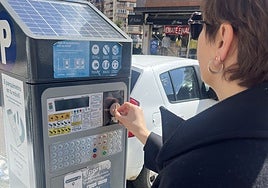 Una usuaria de la zona azul echa monedas en La Pola