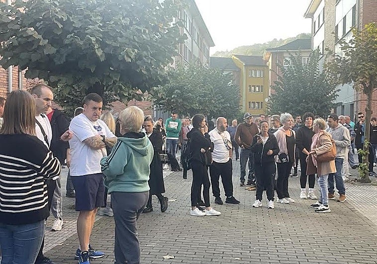 Los vecinos concentrados delante del portal de El Entrego donde se produjo la okupación.