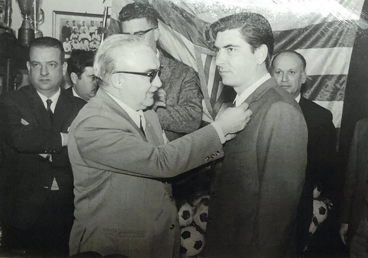 El presidente del Sporting Carlos Méndez Cuervo impone a José González la insignia de oro del Real Gijón de entonces.