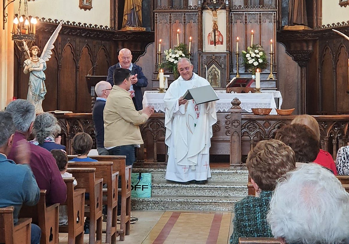 El cura Eduardo Solís, de Cuenya, recibe los obsequios de los vecinos.