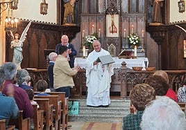 El cura Eduardo Solís, de Cuenya, recibe los obsequios de los vecinos.