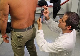 Un doctor toma una fotografía de una lesión dermatológica de un paciente para cargarla al programa de inteligencia artificial que elaborará un informe.