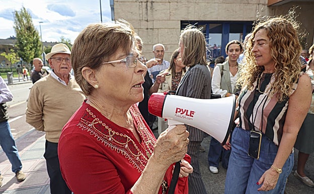 Una señora, megáfono en mano, se queja de la ausencia del alcalde.