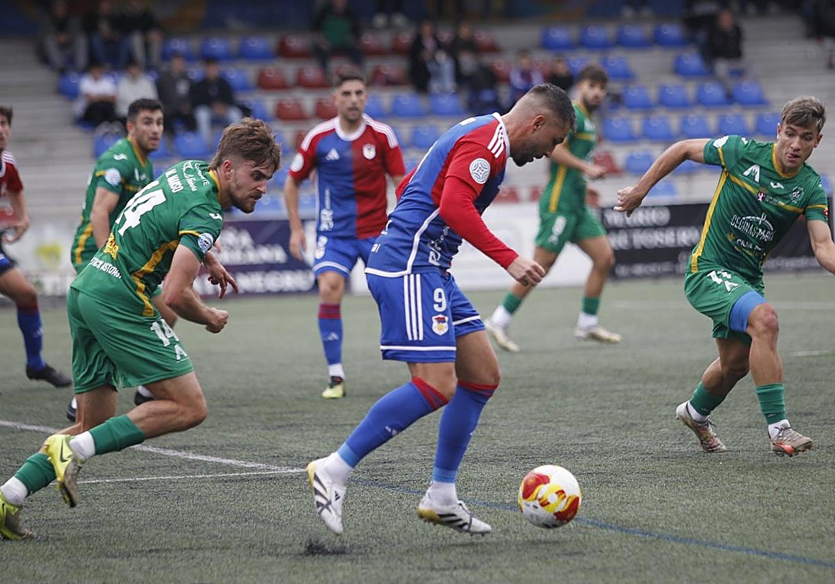 El delantero Miguel Ángel Guerrero, rodeado de rivales, protege el esférico.