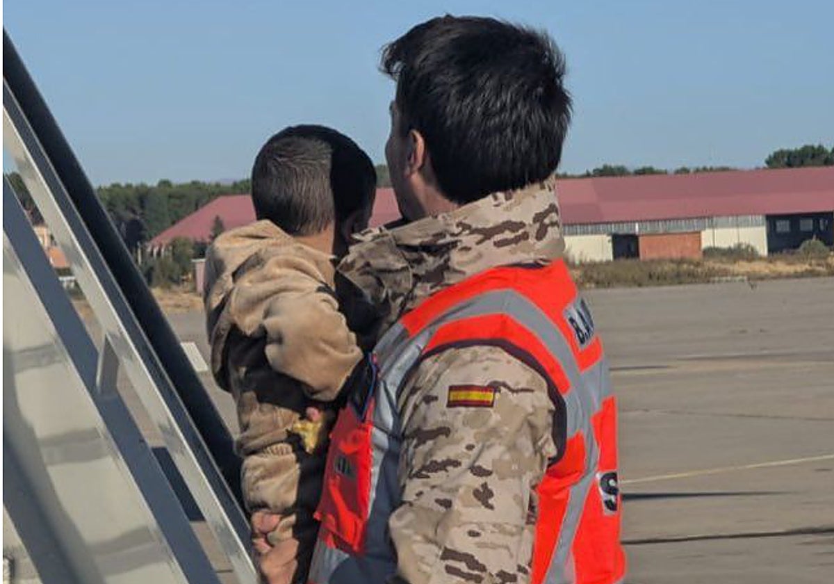 Uno de los pequeños, en brazos de un militar, a su llegada a Torrejón de Ardoz.
