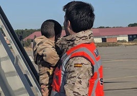 Uno de los pequeños, en brazos de un militar, a su llegada a Torrejón de Ardoz.