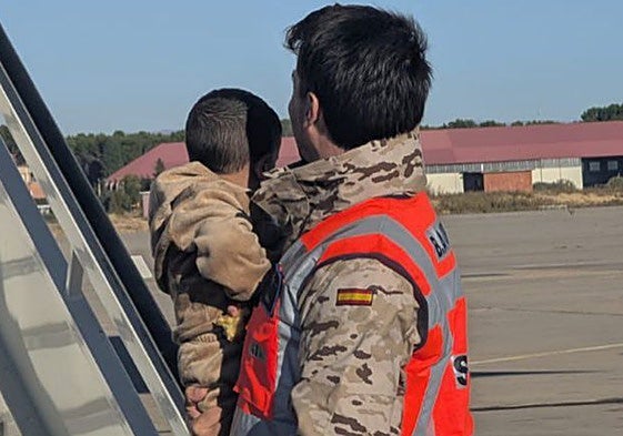 Uno de los pequeños, en brazos de un militar, a su llegada a Torrejón de Ardoz.