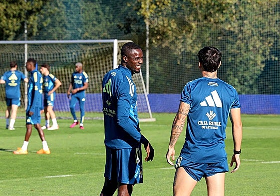 El defensa Bailly bromea con el centrocampista Colombatto en un entrenamiento del Real Oviedo.