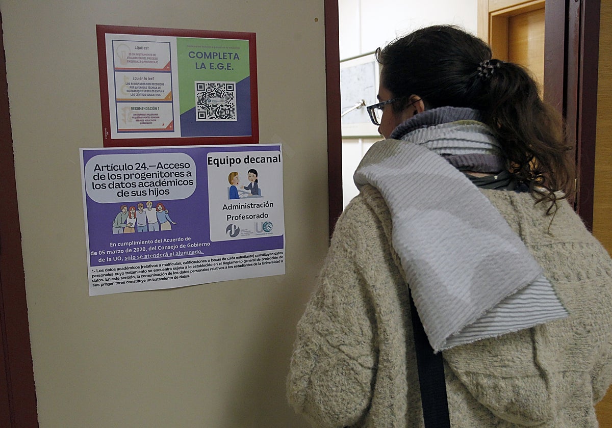 Una alumna lee el cartel de la Facultad de Educación que informa de que no se pueden dar datos a los padres