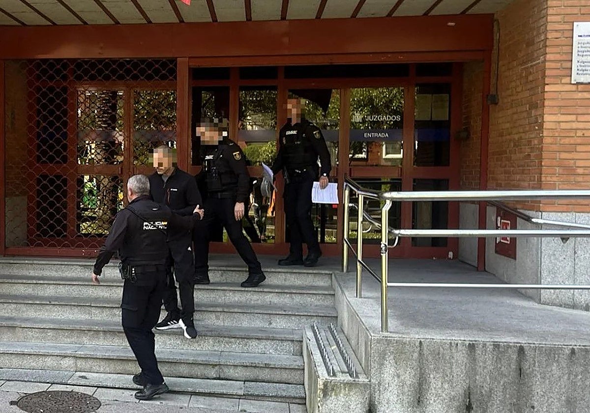 Agentes de la Policía Nacional custodian al detenido a la salida del juzgado de Mieres.